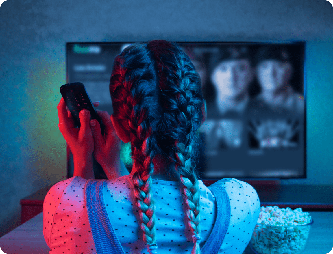 Fille avec une télécommande devant la télé